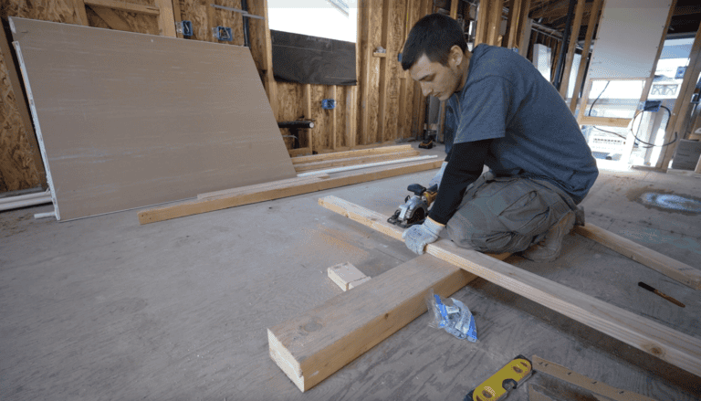 Contractor preparing framing and electrical access for installing a Level 2 EV charger at home.
